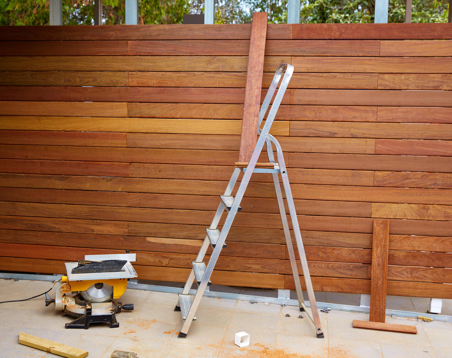 step ladder next to a half built wooden fence